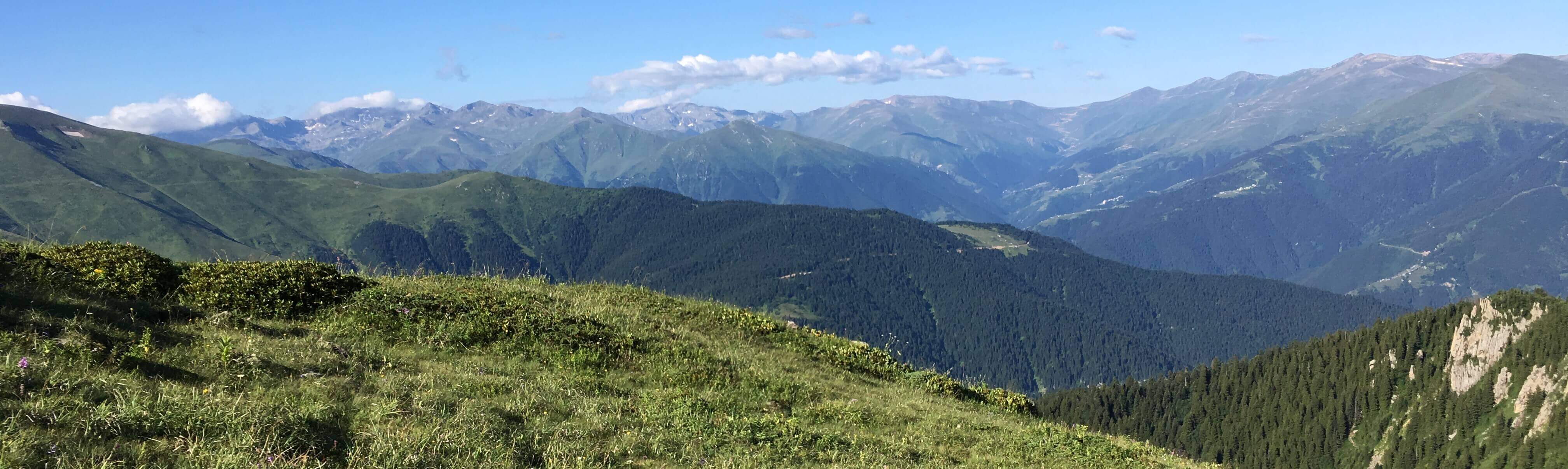 rows of mountain peaks, green in the foreground and blue in the distance